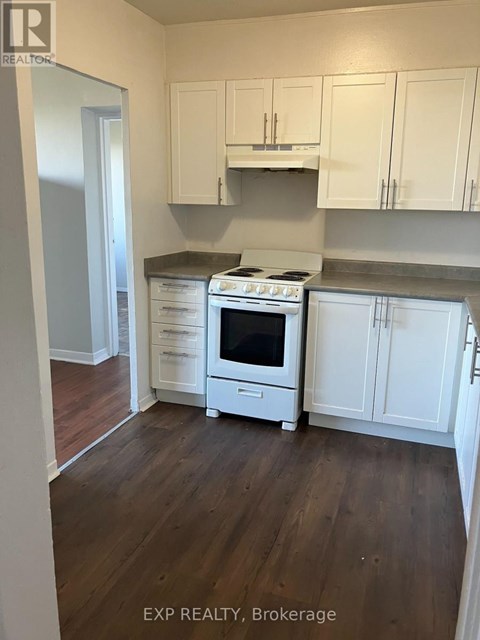 A kitchen with white cabinets and a stove top oven.