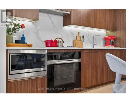 A modern kitchen with wooden cabinets and stainless steel appliances.