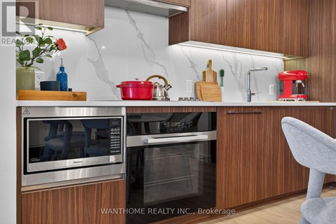 A modern kitchen with wooden cabinets and stainless steel appliances.