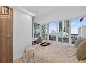 A bedroom with a large bed and a view of the city.