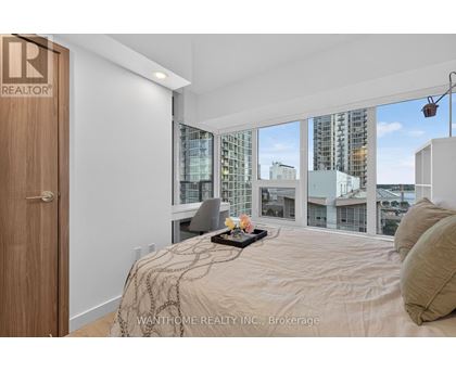 A bedroom with a large bed and a view of the city.
