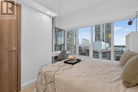 A bedroom with a large bed and a view of the city.