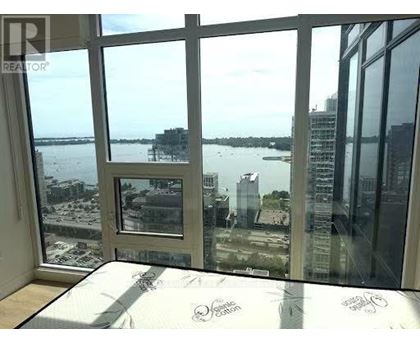 A bedroom with a large bed and a view of the water.