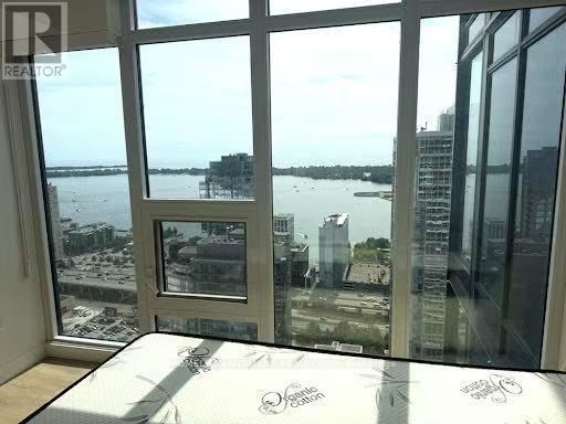 A bedroom with a large bed and a view of the water.