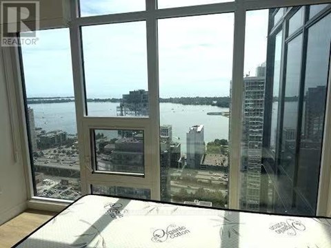 A bedroom with a large bed and a view of the water.