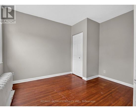 A room with a wooden floor and a white door.