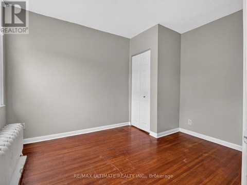 A room with a wooden floor and a white door.