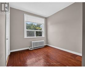 A room with a window and a radiator on the floor.