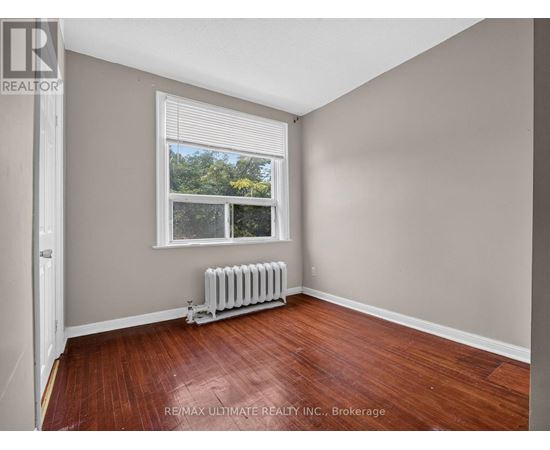 A room with a window and a radiator on the floor.