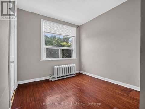 A room with a window and a radiator on the floor.