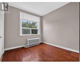 A room with a window and a radiator on the floor.