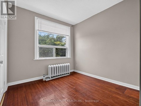 A room with a window and a radiator on the floor.