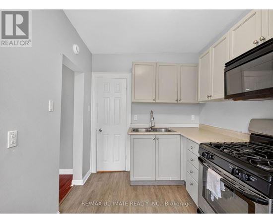 A kitchen with white cabinets and a black stove top oven.