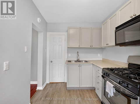 A kitchen with white cabinets and a black stove top oven.