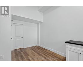 A room with a white door and a white cabinet with a black countertop.