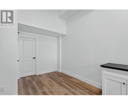 A room with a white door and a white cabinet with a black countertop.