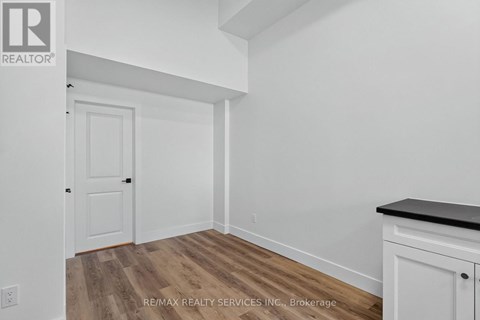 A room with a white door and a white cabinet with a black countertop.