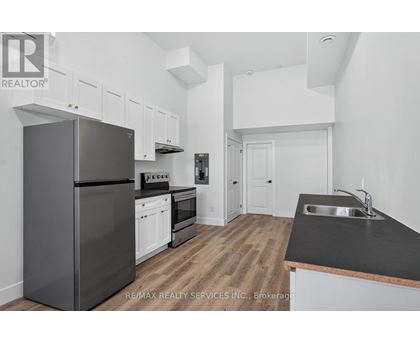 A kitchen with a black counter top and a black refrigerator.