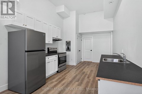 A kitchen with a black counter top and a black refrigerator.