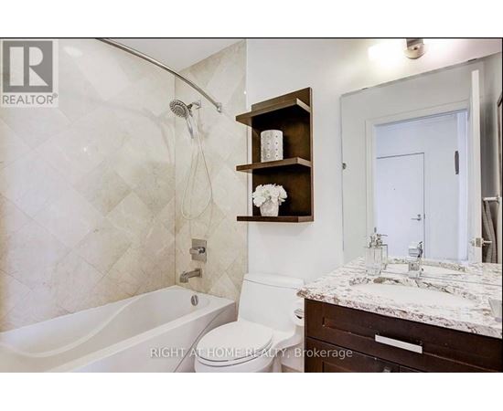 A bathroom with a tub, toilet, and sink.