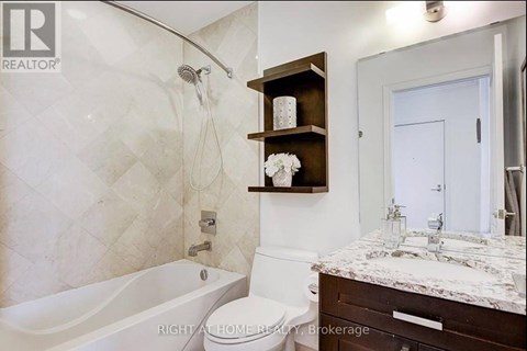 A bathroom with a tub, toilet, and sink.