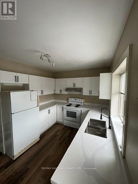 A kitchen with white appliances and cabinets.