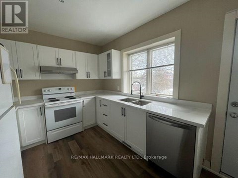 A kitchen with white cabinets and appliances is for sale.