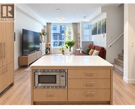 A modern kitchen with wooden cabinets and a microwave oven.