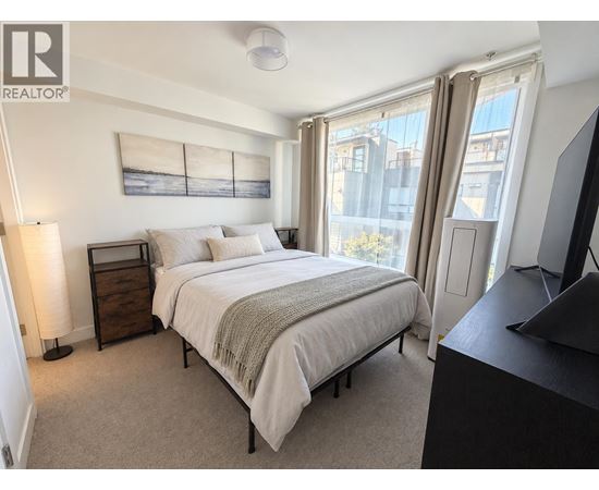 A bedroom with a large bed and a television.