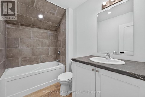A bathroom with a tub, toilet, and sink.