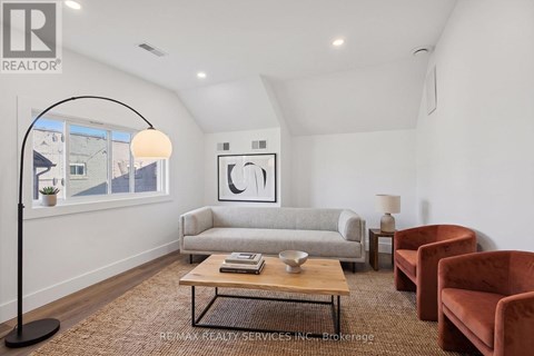A living room with a grey couch, a coffee table, and a lamp.
