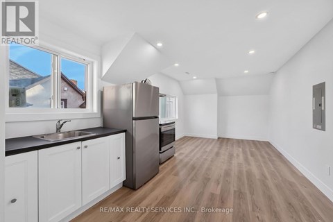 A kitchen with white cabinets and a black countertop.