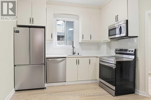 A kitchen with a refrigerator, microwave, oven and dishwasher.