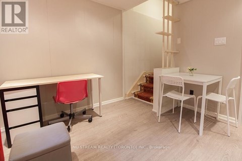 A room with a desk and chairs in it.
