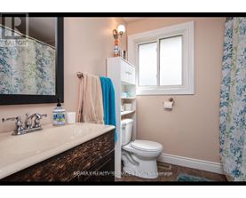 A bathroom with a toilet, sink, and shower curtain.