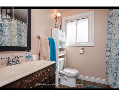 A bathroom with a toilet, sink, and shower curtain.