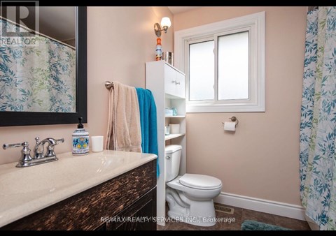 A bathroom with a toilet, sink, and shower curtain.