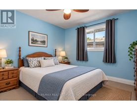 A bedroom with a bed, nightstands, and a ceiling fan.