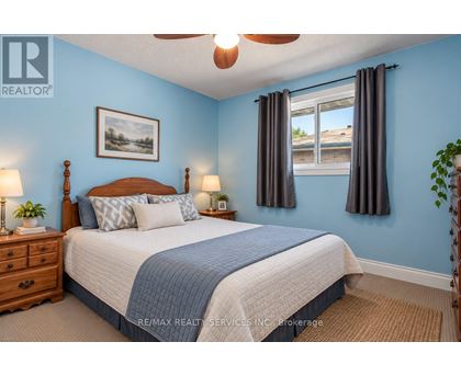 A bedroom with a bed, nightstands, and a ceiling fan.