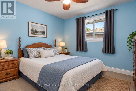 A bedroom with a bed, nightstands, and a ceiling fan.