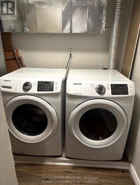 Two front loading washing machines in a small laundry room.