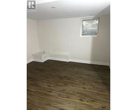 A room with a window and a wooden floor.