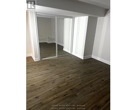 A room with wooden floors and a large mirror.