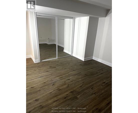 A room with wooden floors and a large mirror.