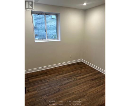 A room with a window and wooden flooring.