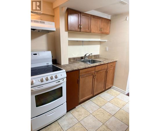 A kitchen with a white stove and wooden cabinets.