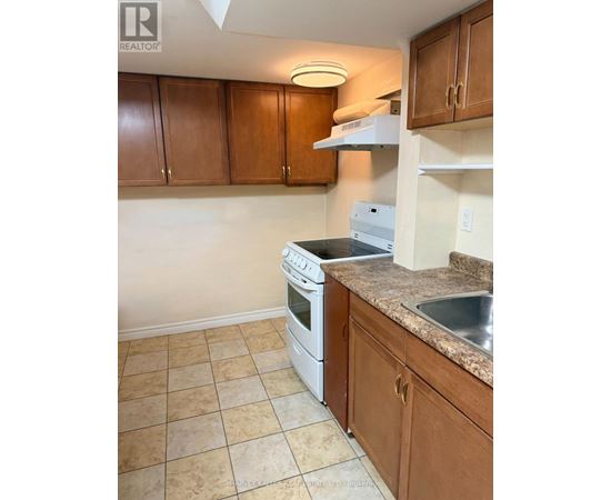 A kitchen with brown cabinets and a white dishwasher.