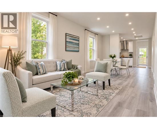 A well-lit living room with a glass coffee table and a grey sofa.