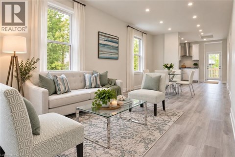 A well-lit living room with a glass coffee table and a grey sofa.