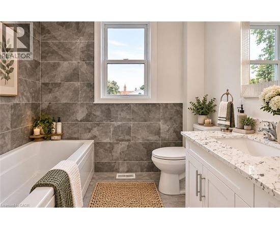 A bathroom with a tub, toilet, and sink.